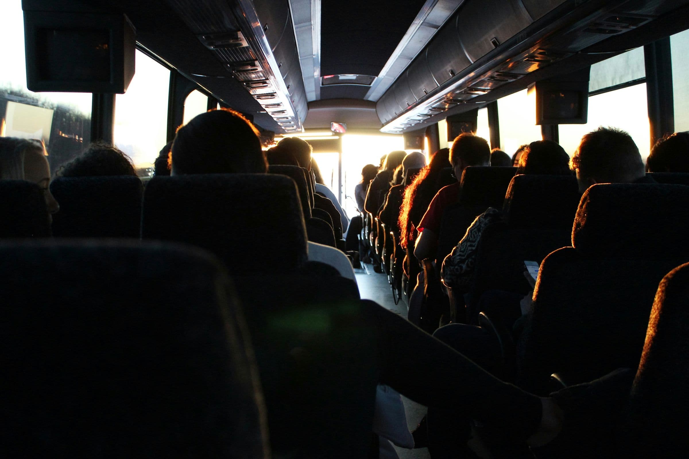 Passeggeri in pullman controluce al tramonto