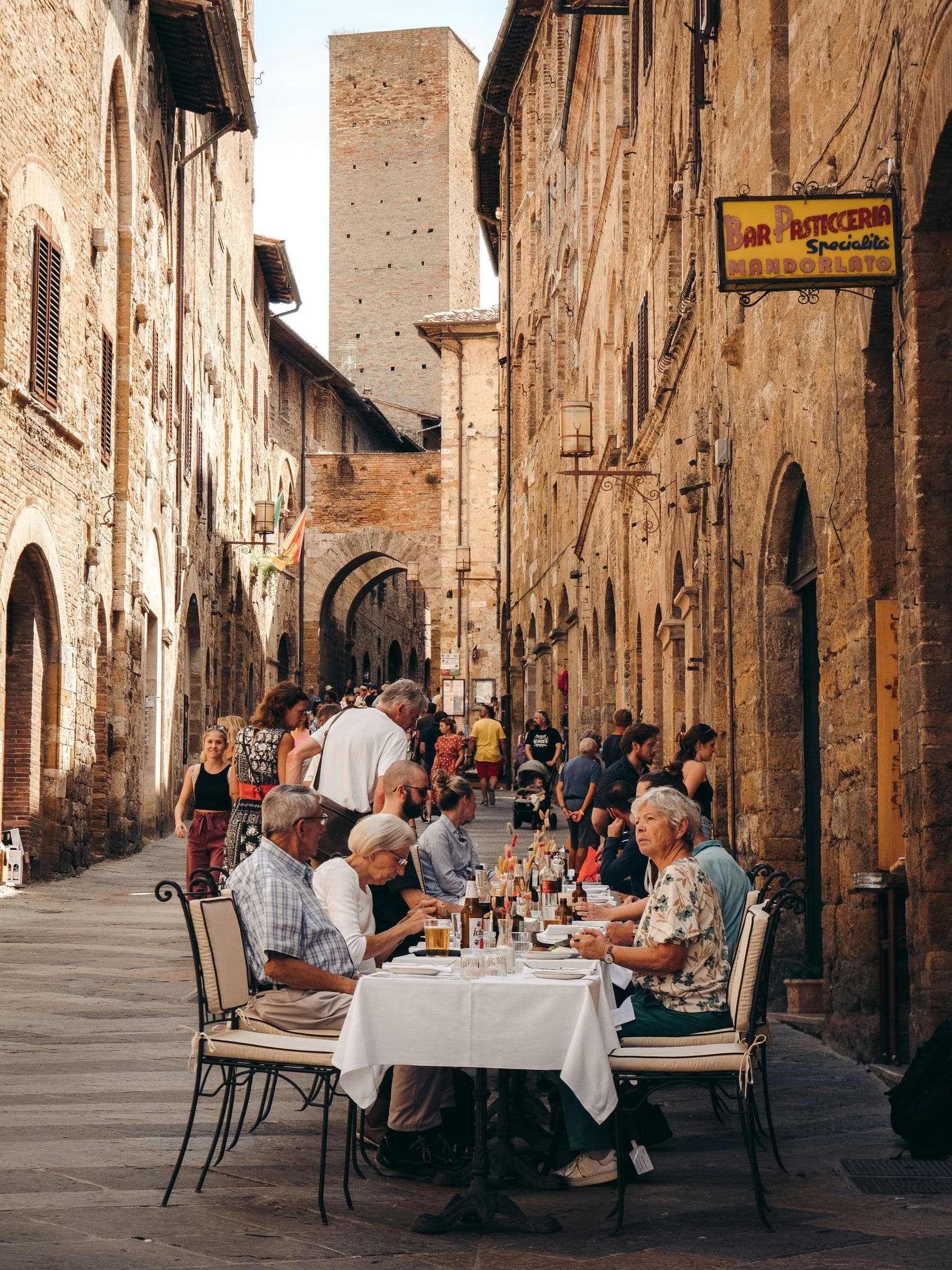 Tavolate all'aperto in una via di pietra di un centro storico medievale